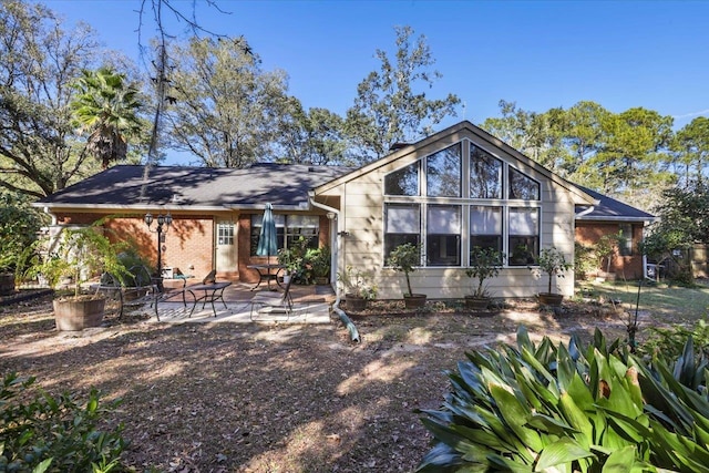 rear view of property with a patio and brick siding