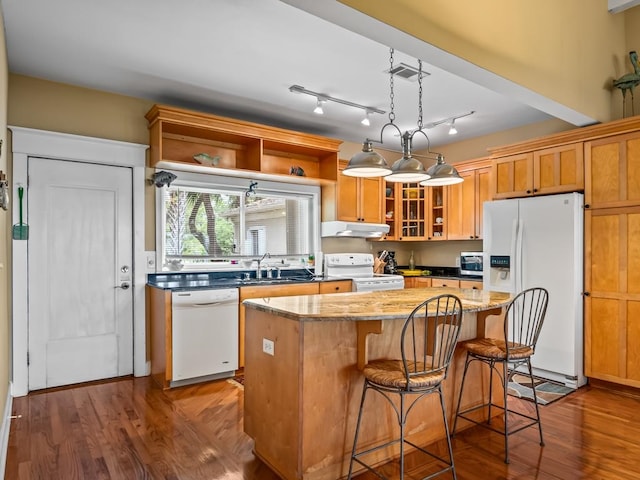 kitchen with a center island, white appliances, sink, decorative light fixtures, and wood-type flooring