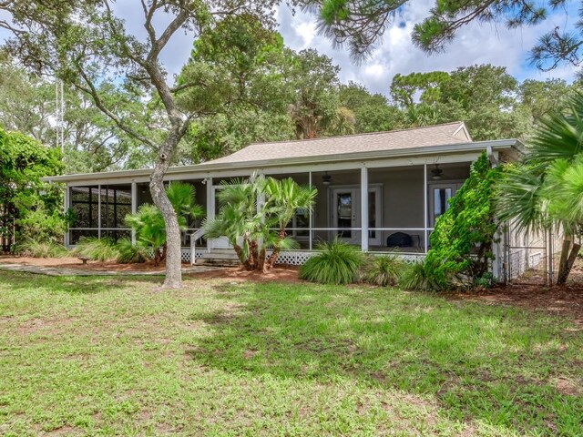 back of house featuring a yard and a sunroom