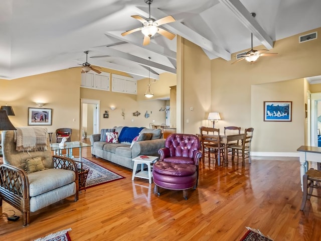 living room featuring ceiling fan, hardwood / wood-style floors, beamed ceiling, and high vaulted ceiling