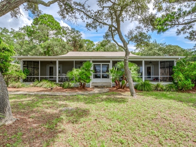 view of front of home with a sunroom and a front lawn