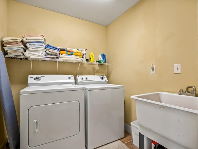 laundry area with light tile patterned floors, sink, and washing machine and clothes dryer