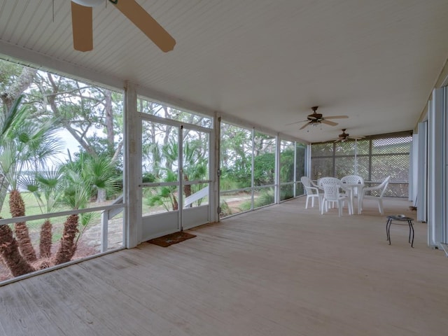 unfurnished sunroom with ceiling fan