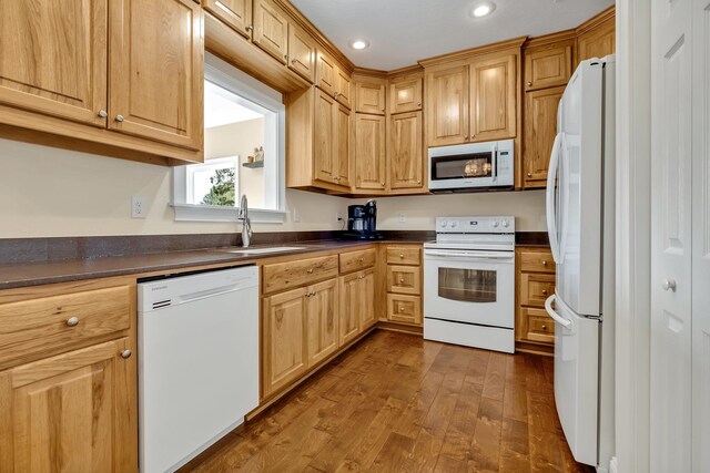 kitchen with dark hardwood / wood-style flooring, white appliances, and sink