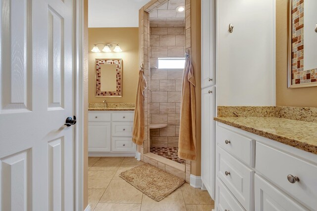 bathroom featuring vanity, tile patterned floors, and a tile shower