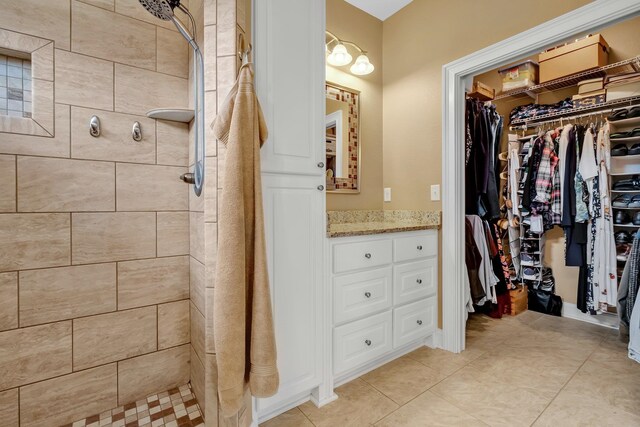 bathroom with vanity, tile patterned floors, and a tile shower