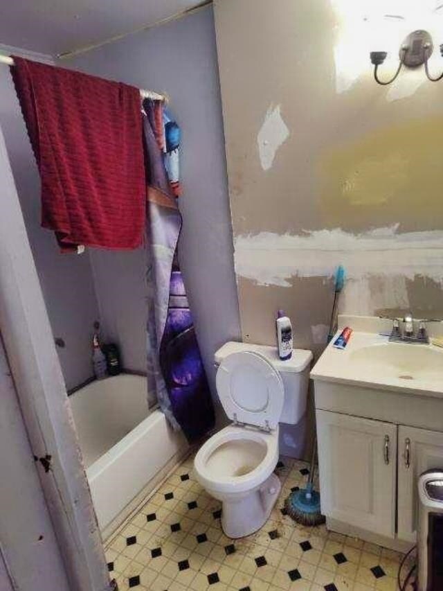 full bathroom featuring vanity, shower / bath combination with curtain, and toilet