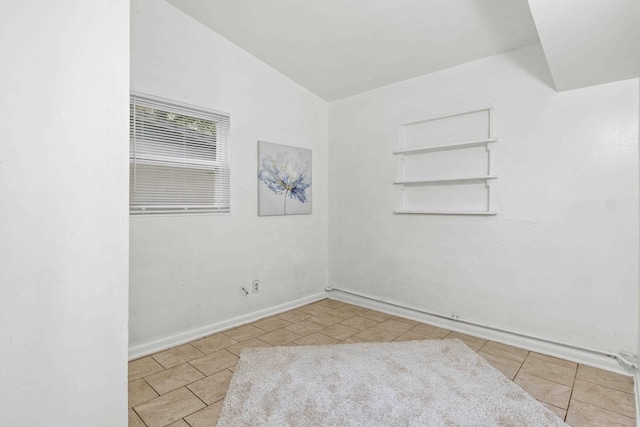 unfurnished room featuring light tile patterned floors and vaulted ceiling