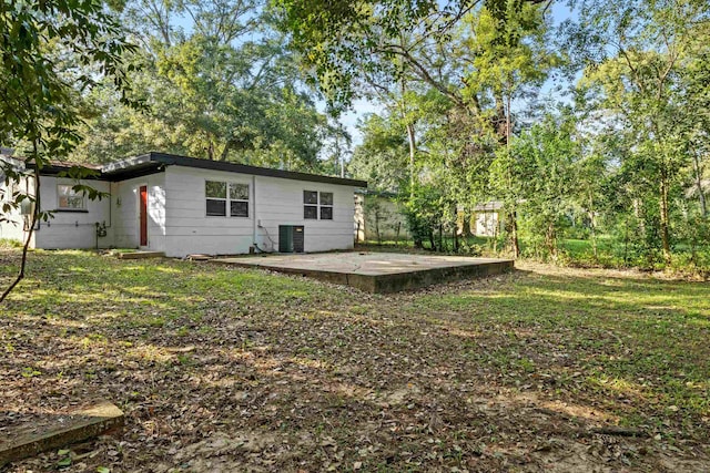 back of property with a yard, cooling unit, and a patio area