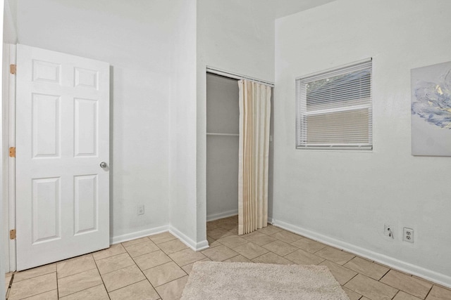 unfurnished bedroom with a closet and light tile patterned floors