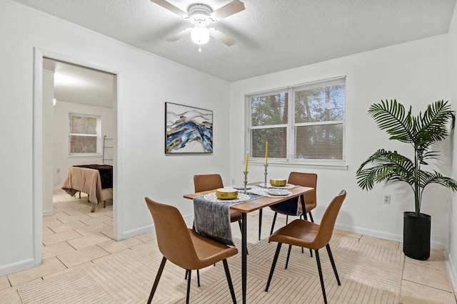 tiled dining room with a textured ceiling and ceiling fan