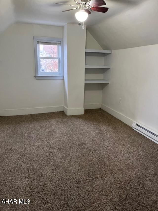 additional living space with vaulted ceiling, a baseboard heating unit, carpet flooring, and baseboards