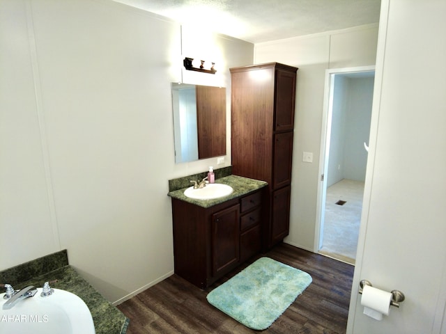 bathroom with hardwood / wood-style floors, vanity, and a textured ceiling