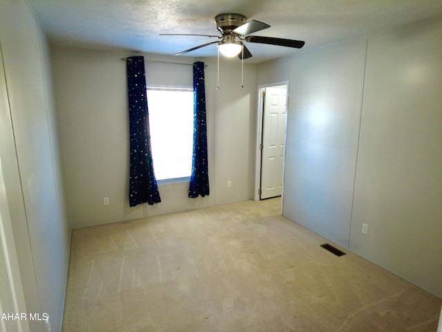 carpeted empty room featuring a textured ceiling and ceiling fan