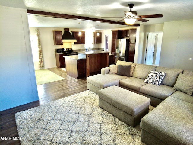 living room with ceiling fan, light hardwood / wood-style flooring, a textured ceiling, and sink