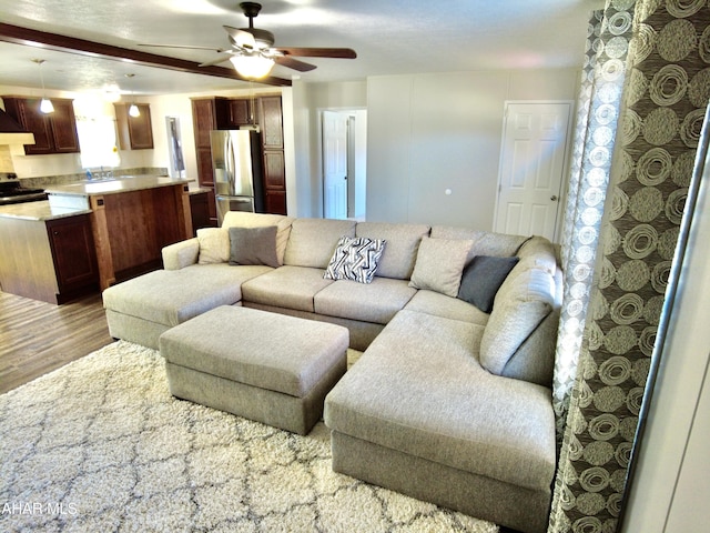 living room with hardwood / wood-style floors, ceiling fan, and sink