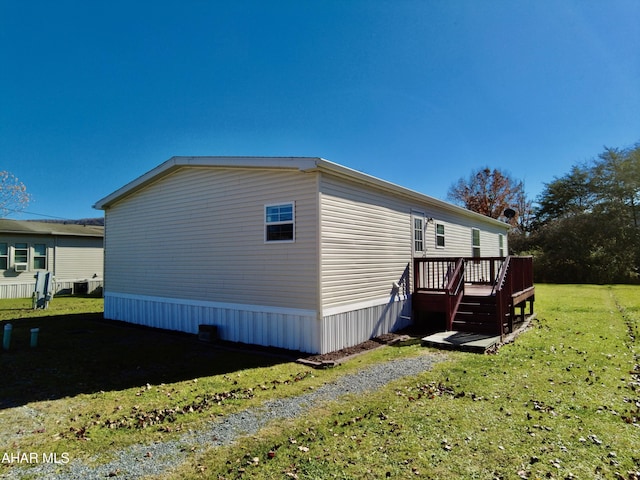 view of side of property with a deck and a yard