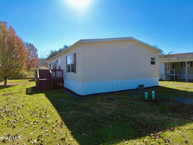 view of home's exterior with a lawn and a deck