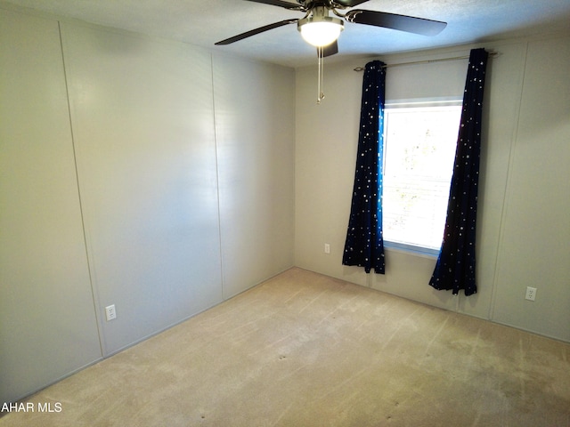 unfurnished room featuring a textured ceiling, light colored carpet, and ceiling fan