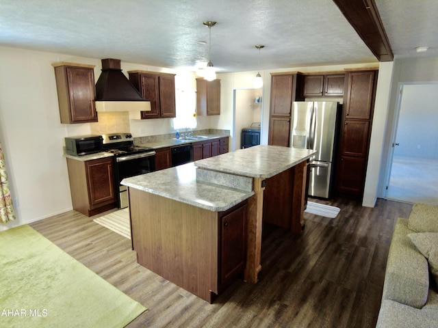 kitchen featuring hanging light fixtures, stainless steel appliances, dark hardwood / wood-style flooring, premium range hood, and a kitchen island