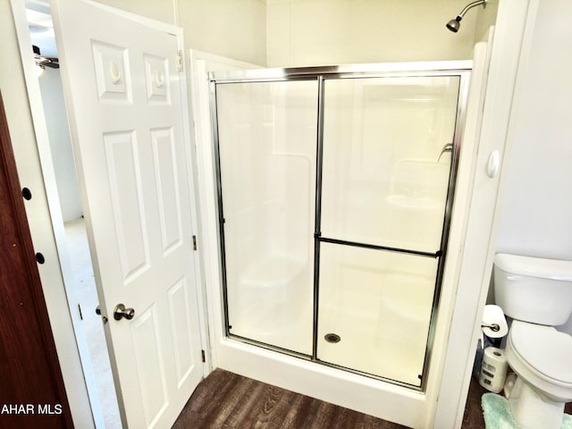 bathroom featuring hardwood / wood-style floors, toilet, and an enclosed shower