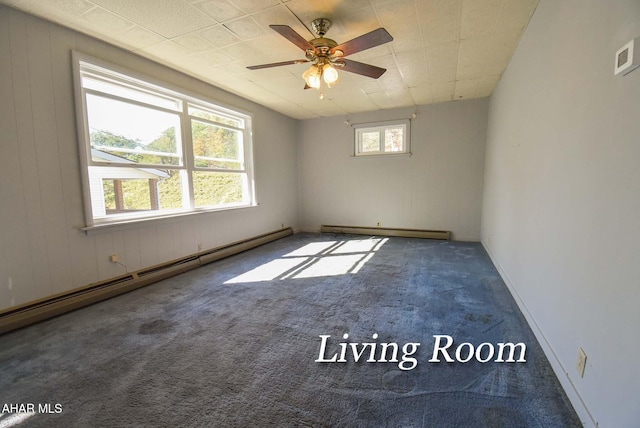 carpeted empty room with a baseboard heating unit, wooden walls, and ceiling fan