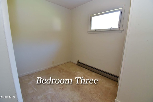 carpeted spare room with baseboard heating