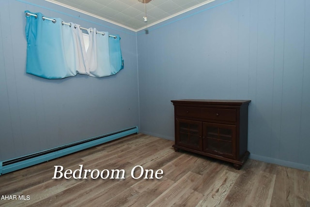 empty room with light hardwood / wood-style flooring, a baseboard radiator, and ornamental molding