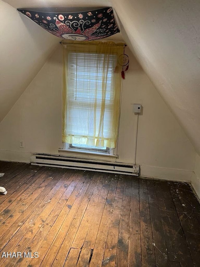 additional living space with lofted ceiling, baseboard heating, and wood-type flooring