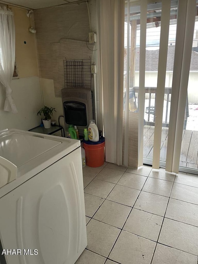 washroom featuring washer / dryer, light tile patterned floors, and heating unit