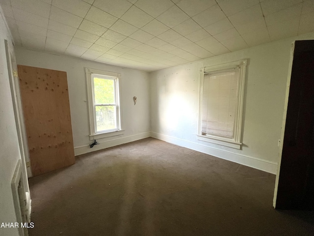empty room featuring carpet and baseboards