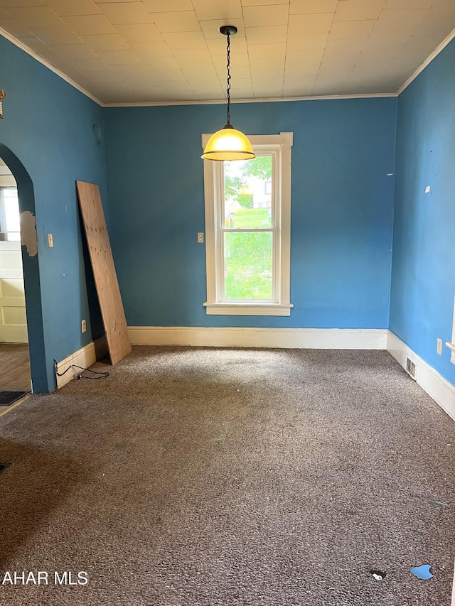 unfurnished room featuring arched walkways, crown molding, baseboards, and carpet floors