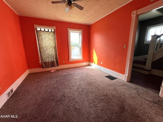 unfurnished room featuring ornamental molding, a ceiling fan, carpet flooring, and baseboards