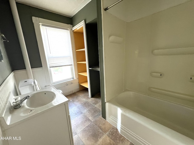bathroom with vanity, stone finish floors, and shower / bathtub combination