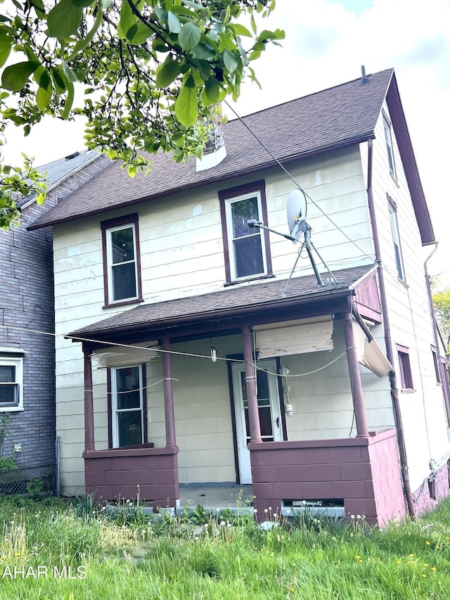 view of front facade featuring covered porch and roof with shingles