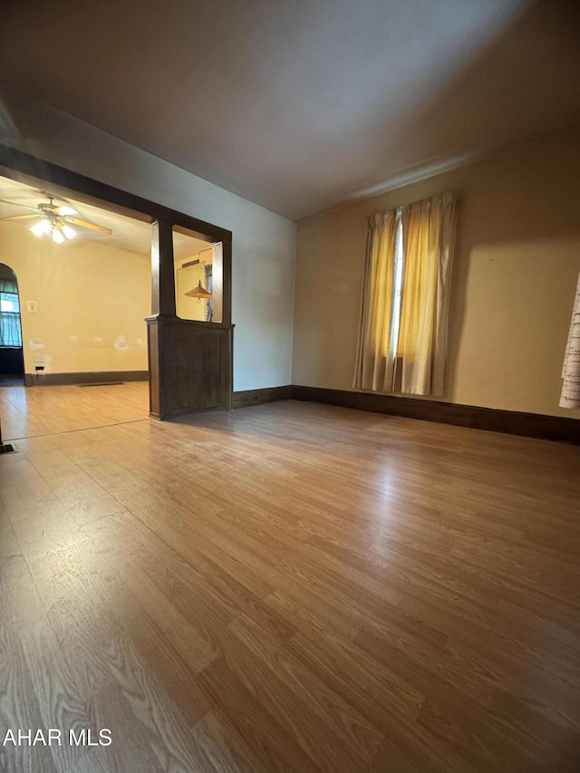 607 N N 8th Ave, Altoona, PA 16601 - empty room with wood finished floors, a ceiling fan, and arched walkways
