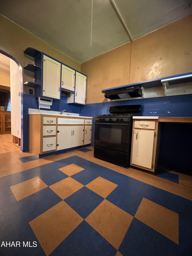 607 N N 8th Ave, Altoona, PA 16601 - kitchen with black gas stove, under cabinet range hood, open shelves, arched walkways, and light floors