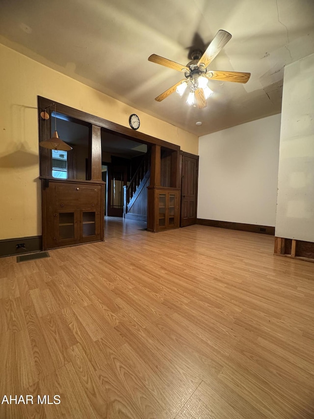 607 N N 8th Ave, Altoona, PA 16601 - unfurnished living room with stairway, light wood-style flooring, and a ceiling fan