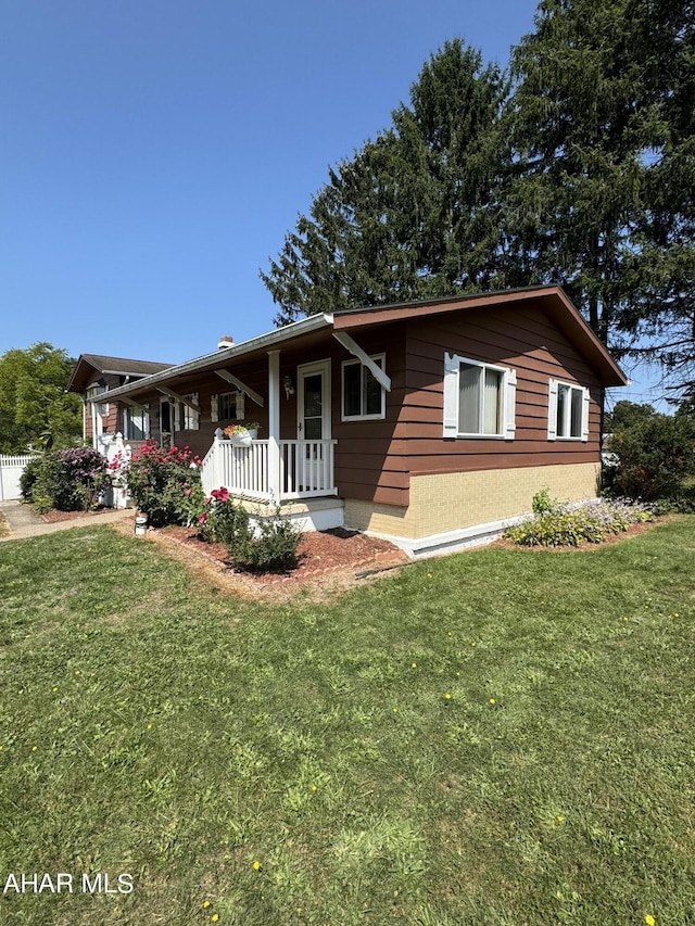 ranch-style home featuring a porch and a front yard