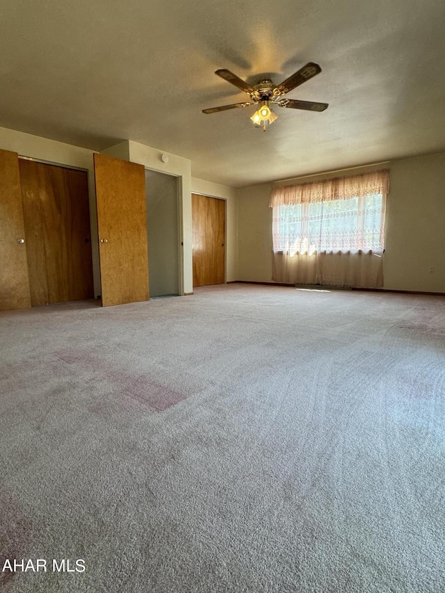 spare room with ceiling fan and carpet