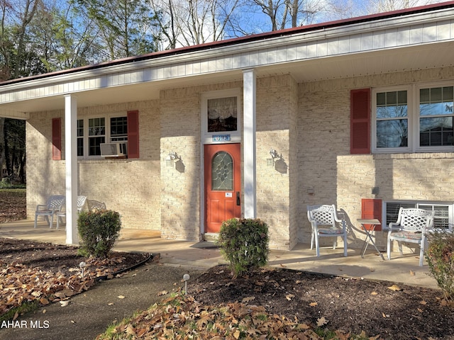 view of exterior entry with cooling unit and covered porch