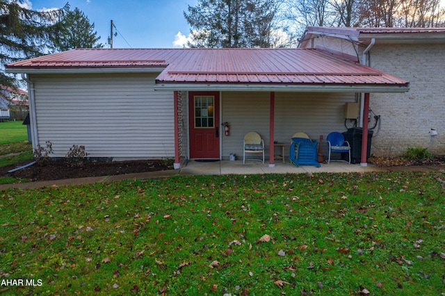 rear view of property featuring a lawn and a patio