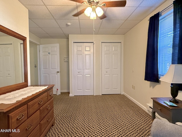 carpeted bedroom featuring a drop ceiling and ceiling fan