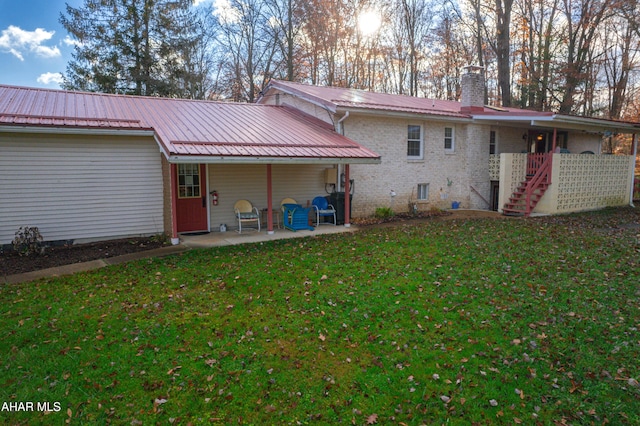 back of property featuring a yard and a patio area