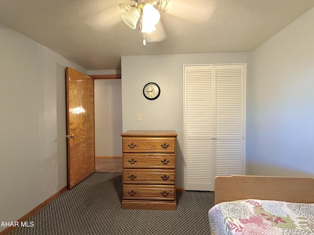 bedroom with dark colored carpet, ceiling fan, and a closet