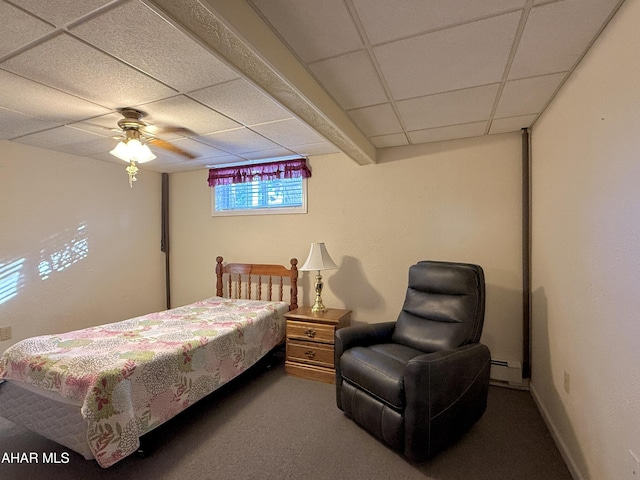 carpeted bedroom with ceiling fan, a drop ceiling, and a baseboard radiator