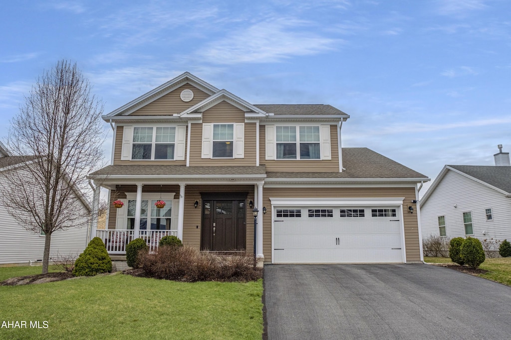 view of front facade featuring a porch, driveway, a shingled roof, and a front lawn