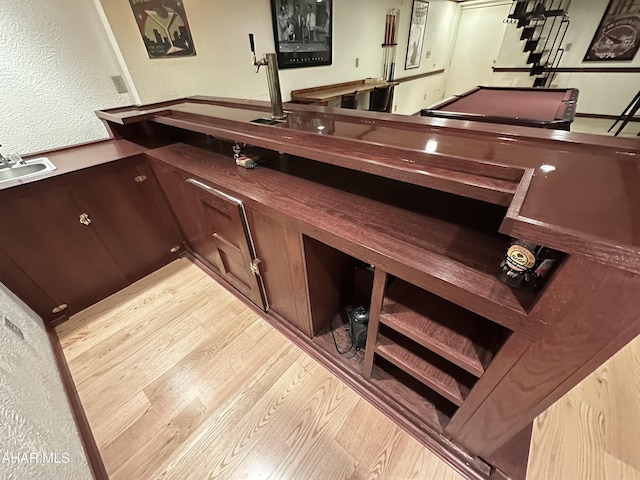 bar with sink and light hardwood / wood-style floors