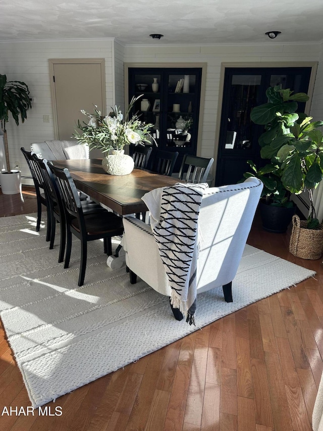 dining room with ornamental molding and wood-type flooring