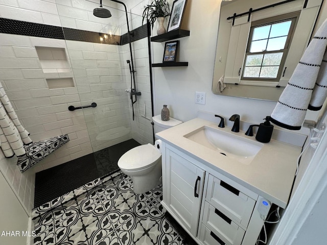 bathroom with vanity, toilet, and tiled shower